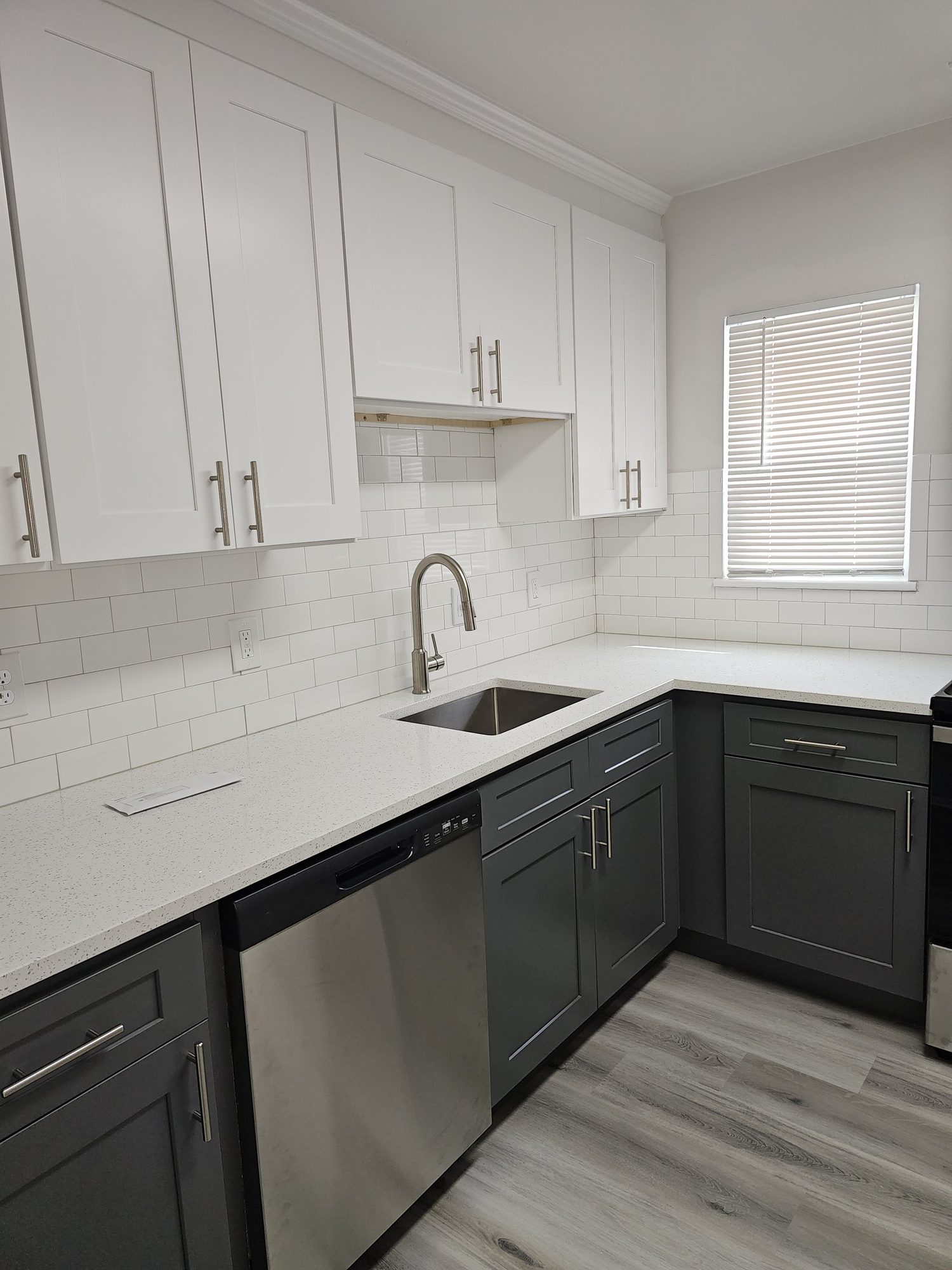 Archers Green renovated kitchen with white upper and gray lower shaker cabinets and subway tile