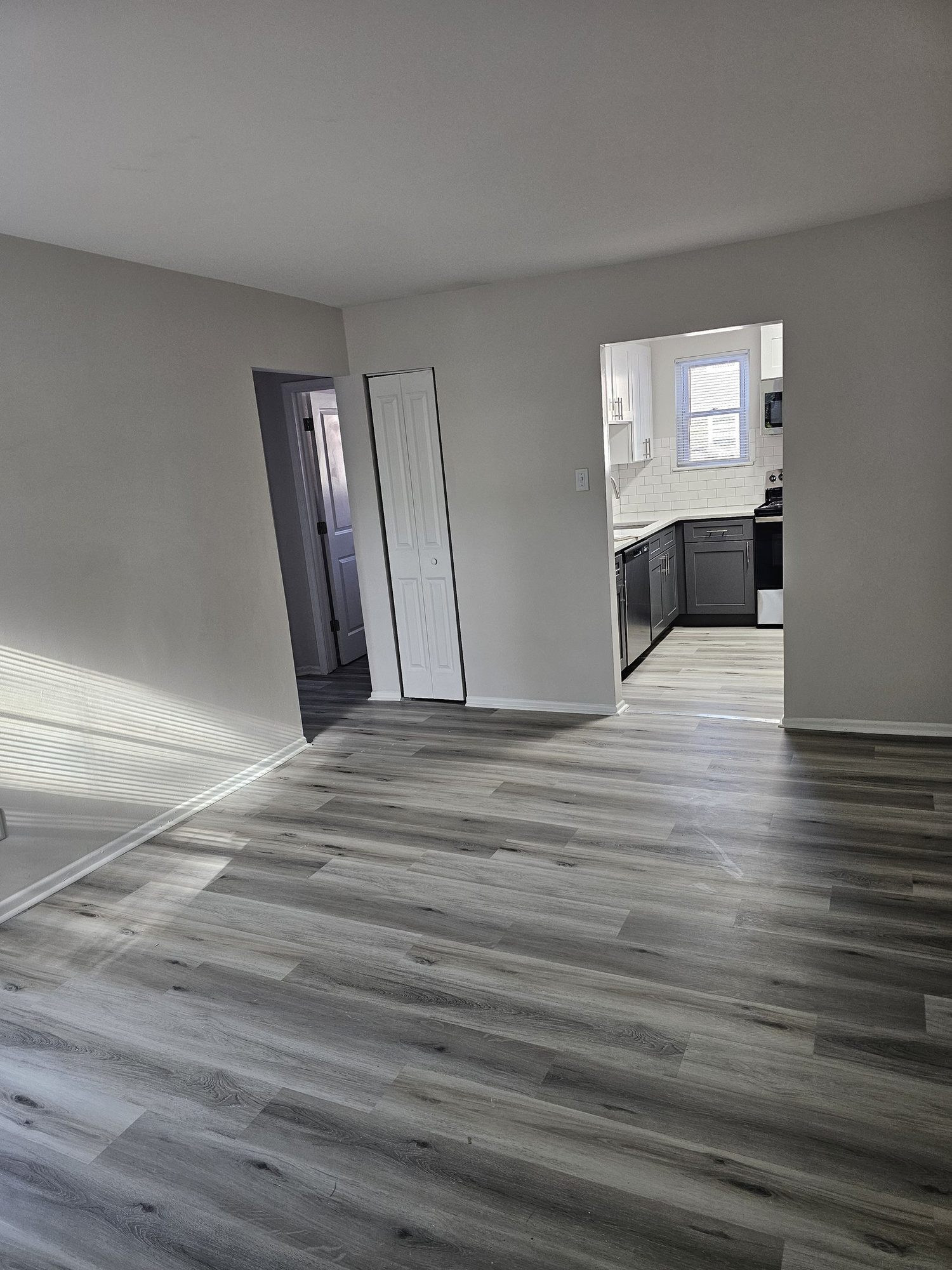 Archers Green renovated living area with new plank flooring and view into the kitchen